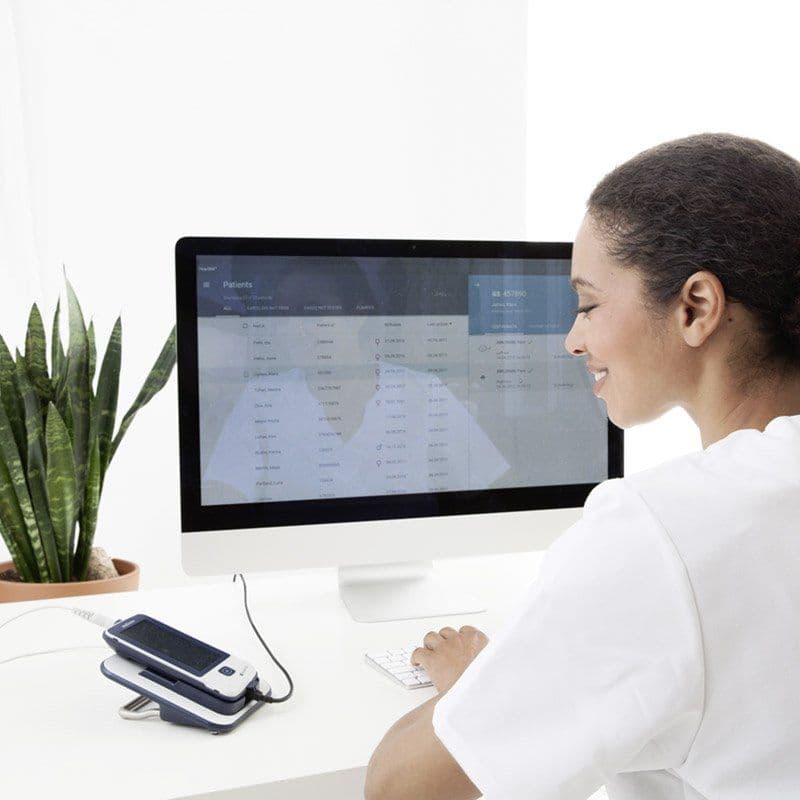 Doctor by a computer looking at a MAICO easyScreen